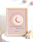 Moon and star pink nursery wall art with Numbers 6:24 blessing displayed in a baby's room