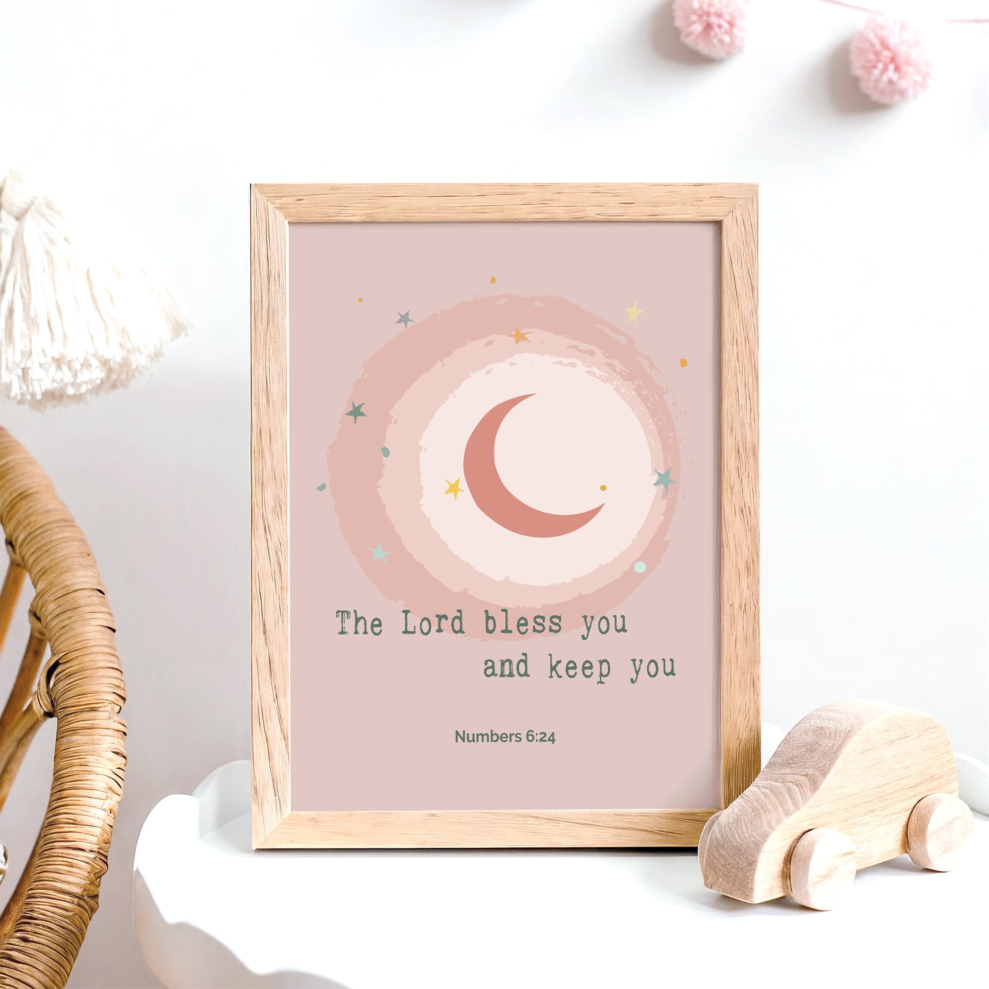 Moon and star pink nursery wall art with Numbers 6:24 blessing displayed in a baby's room